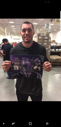 a man holding up a poster in a store